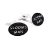 Cufflinks with black round faces reading 'GROOMSMAN'.