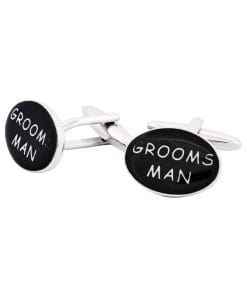 Pair of shiny cufflinks with black circular faces, each displaying white text that together reads 'GROOM' and 'MAN'.