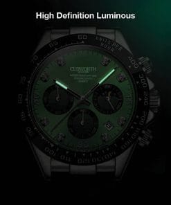 Close-up of a luxury wristwatch with a green luminous dial, black bezel, and three subdials against a dark background, metal bracelet visible.