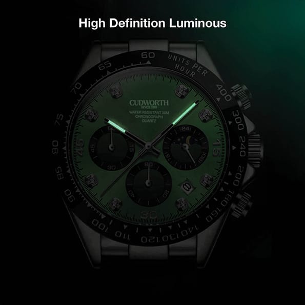 CU2875WTGR05 | Cudworth Close-up of a luxury wristwatch with a green luminous dial, black bezel, and three subdials against a dark background, metal bracelet visible.