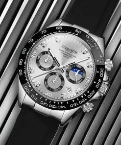 Close-up of a silver luxury wristwatch with a black bezel, multiple subdials, and a date window on a striped background, showcasing chronograph features and a moon phase indicator.