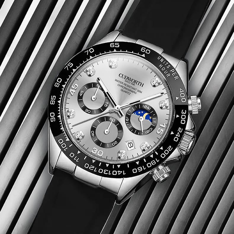 CU2875WTSV06 | Cudworth Close-up of a silver luxury wristwatch with a black bezel, multiple subdials, and a date window on a striped background, showcasing chronograph features and a moon phase indicator.